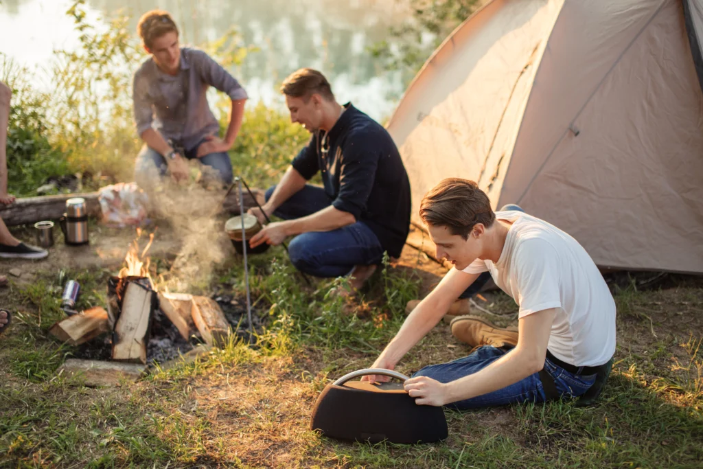 Campers cooking around a portable stove at sunset