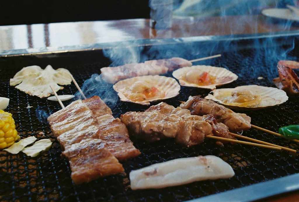 BBQ grill with burgers, hot dogs, and corn on the cob with American flag napkins
